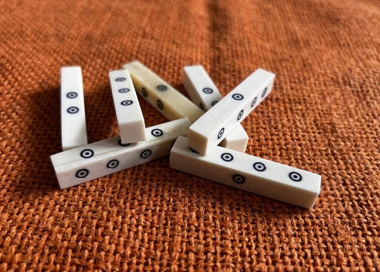 Beinwürfel nach zahlreichen Funden der Römerzeit, polierter Knochen mit Einlage aus Ebenholzstaub, ca. 5 x 1 cm