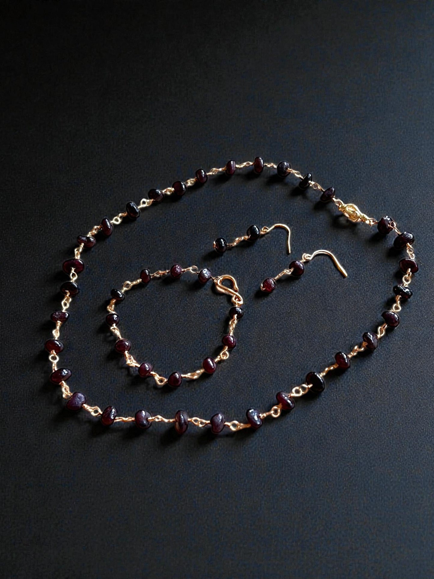 Entdecke unser antikes Granatperlen-Set, bestehend aus Kette, Ohrringen und Armband aus vergoldetem Kupfer. Alllerikerfreundliche Ohrhaken und zeitloses Design
