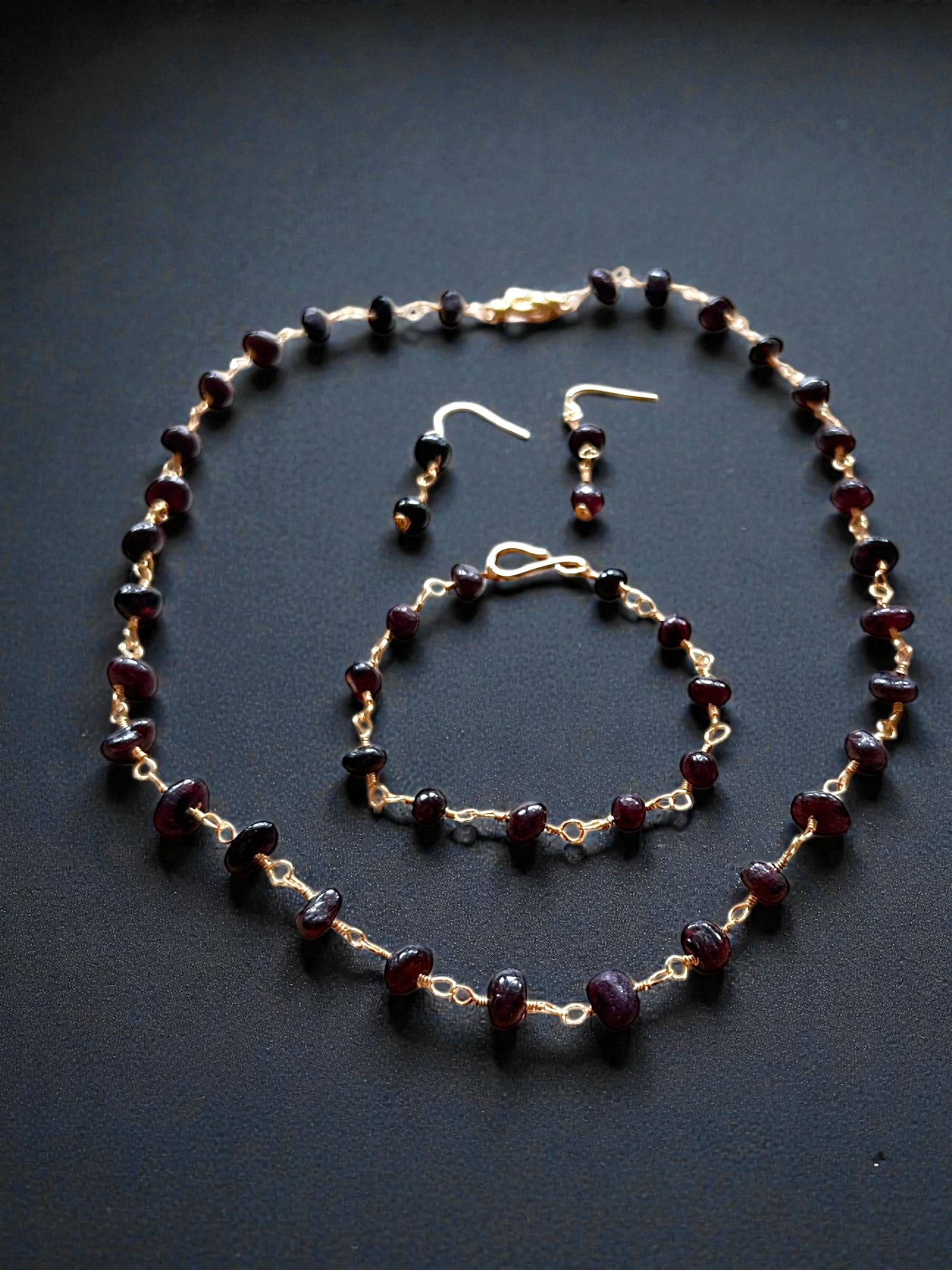 Entdecke unser antikes Granatperlen-Set, bestehend aus Kette, Ohrringen und Armband aus vergoldetem Kupfer. Alllerikerfreundliche Ohrhaken und zeitloses Design
